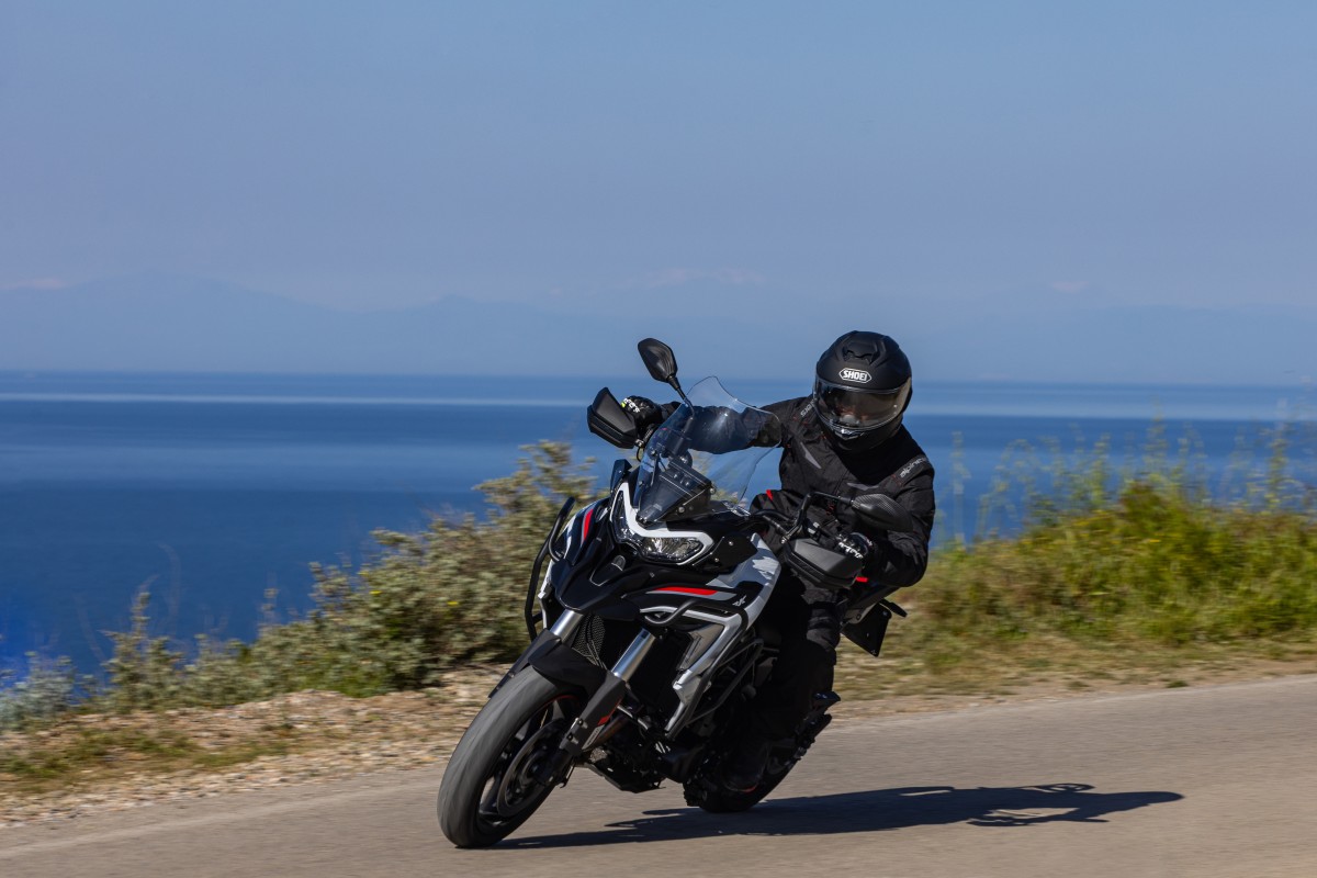 A Benelli adventure motorcycle riding along the coast